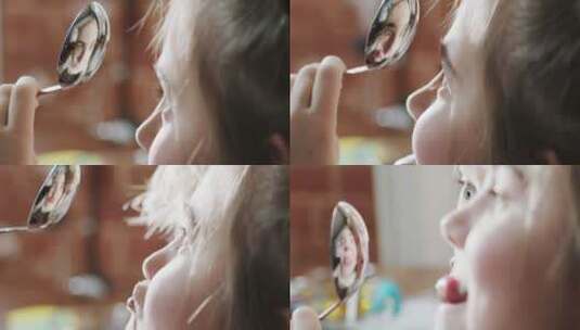 女孩用不锈钢勺子当镜子做鬼脸高清在线视频素材下载