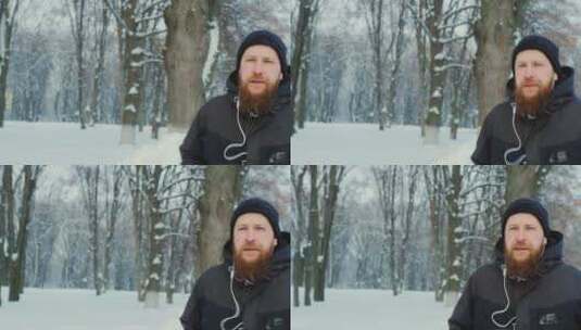 男人戴耳机在冬天的公园里跑步高清在线视频素材下载