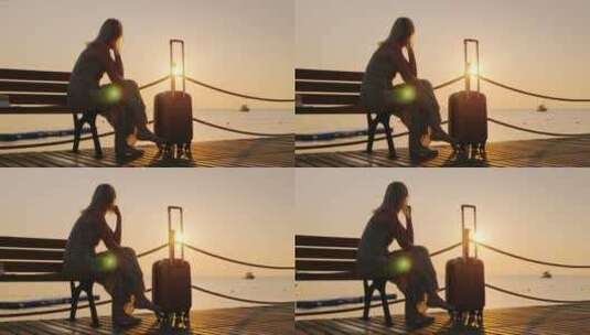 女人坐在海桥上的长椅上看日落高清在线视频素材下载