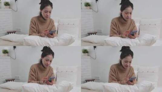美女在家坐在床上敷着面膜玩手机高清在线视频素材下载