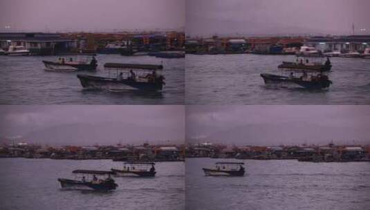 海南岛渔港清晨 渔船驶过蛋民船屋高清在线视频素材下载