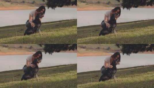 女人在草地上抚摸她的狗高清在线视频素材下载