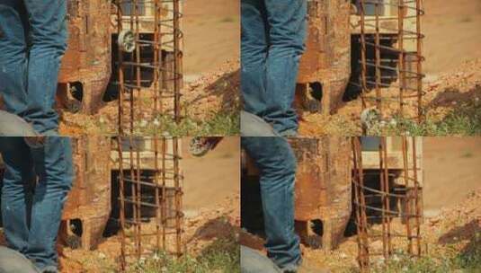 拖拉机举起一根钢棒，把它放在地上的一个洞里。建筑工人正在帮助他高清在线视频素材下载