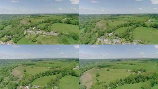 德文郡乡村山顶上一个古雅的英国村庄上空的空中跟踪高清在线视频素材下载