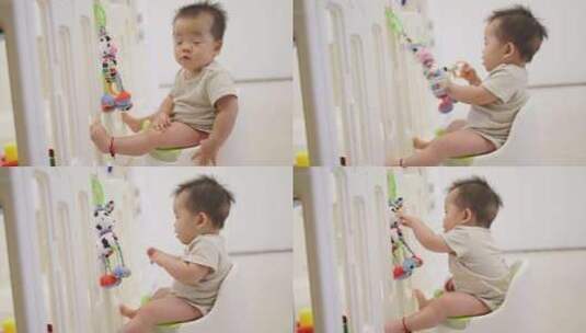 亚洲小孩中国宝宝坐在小马桶上拉屎玩玩具高清在线视频素材下载
