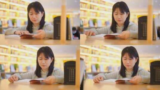 年轻女子图书馆在书架前翻看书本学习高清在线视频素材下载