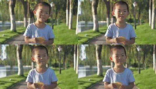 小朋友在公园树林中吃饼干玩玩具高清在线视频素材下载