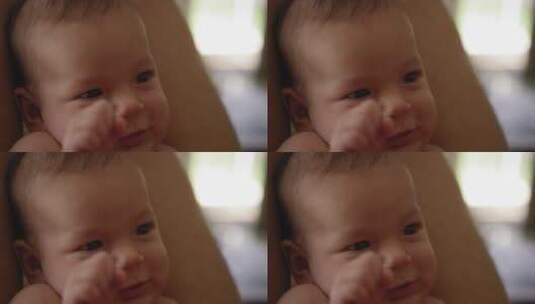 婴儿靠在成人腿上微笑和握手高清在线视频素材下载