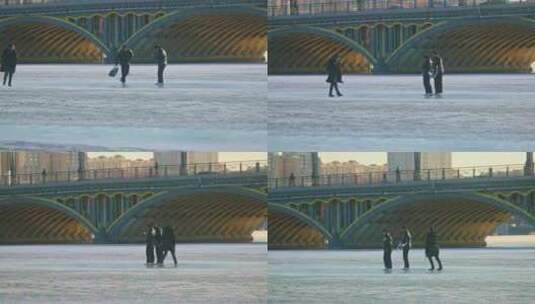 结冰湖面青年人游玩 冰面滑行 壮观大桥唯美高清在线视频素材下载
