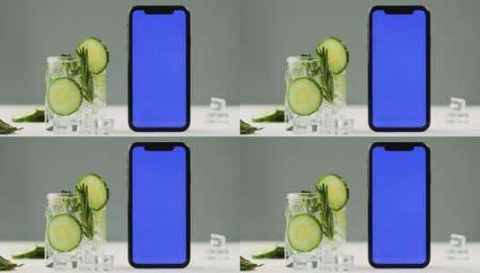 黄瓜切片在杯中和旁边的手机的画面特写高清在线视频素材下载