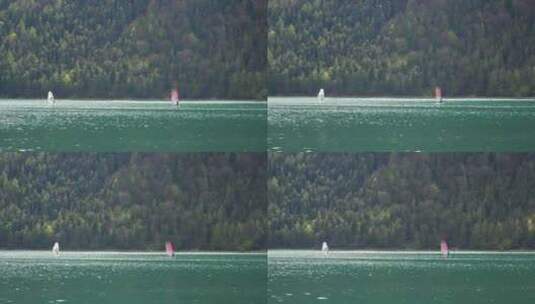 在山上的阿琴湖上滑浪风帆。奥地利阿尔卑斯山的水上运动。高清在线视频素材下载