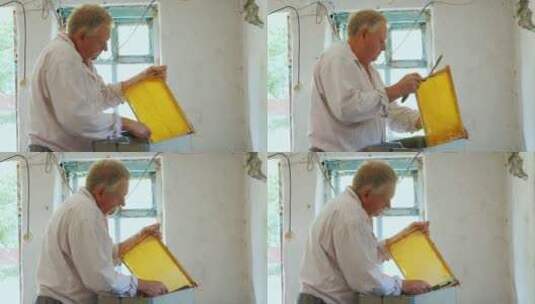 老人在刮取蜂蜜高清在线视频素材下载
