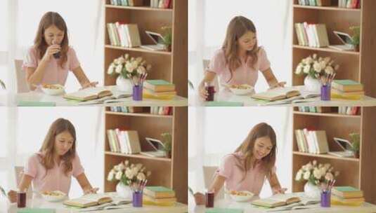 女孩坐在桌旁看书吃沙拉高清在线视频素材下载