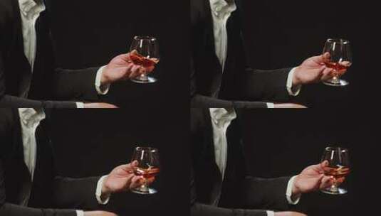 男人摇晃着手中的红酒杯特写镜头高清在线视频素材下载