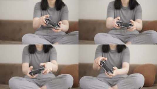年轻女孩坐在沙发上拿着遥控器玩游戏高清在线视频素材下载