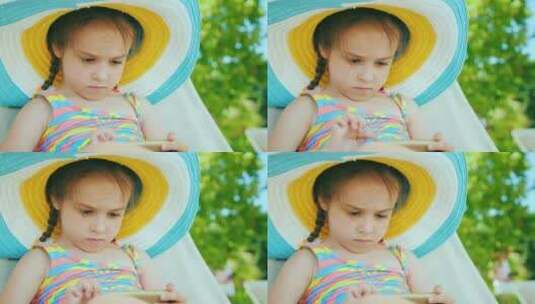 可爱的女孩戴着帽子玩智能手机高清在线视频素材下载