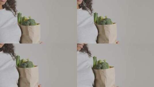 女人拿着蔬菜纸袋高清在线视频素材下载