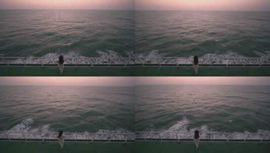 年轻女孩在轮船甲板上看海上夕阳高清在线视频素材下载