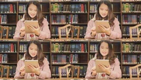 女留学生在图书馆使用电子设备学习高清在线视频素材下载