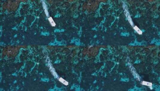 潜水船在热带珊瑚礁系统上空穿过水面的独特景色。高无人机视图高清在线视频素材下载