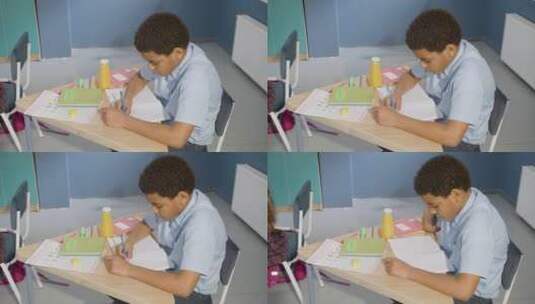 男孩坐在书桌前写字高清在线视频素材下载