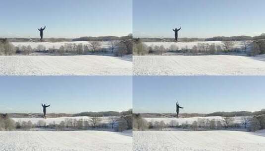 男子在白雪覆盖的田野上走钢丝高清在线视频素材下载