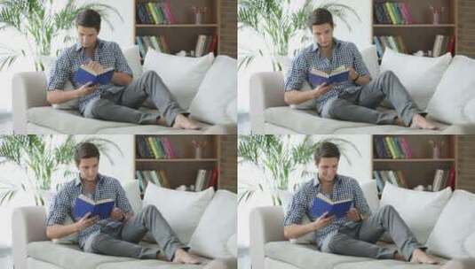 年轻人坐在沙发上看书高清在线视频素材下载