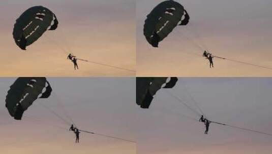 一对情侣在夕阳中享受滑翔伞运动_高清在线视频素材下载