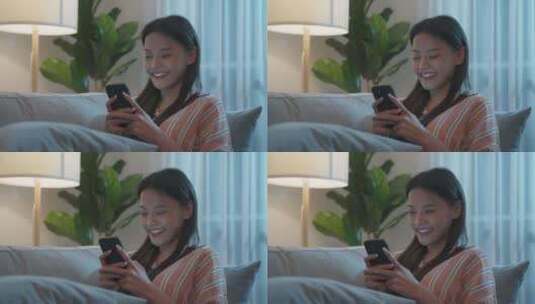 亚洲美女晚上坐在沙发上用手机聊天高清在线视频素材下载