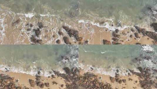 俯拍海岸礁石沙滩海水拍打岩石浪花潮水冲刷高清在线视频素材下载
