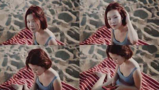 十几岁的女孩在海滩玩电子游戏高清在线视频素材下载