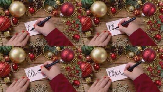 在圣诞装饰品附近手写圣诞贺卡高清在线视频素材下载