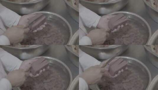 羊汤制作厨师在手掌中切割羊血豆腐中景LOG高清在线视频素材下载