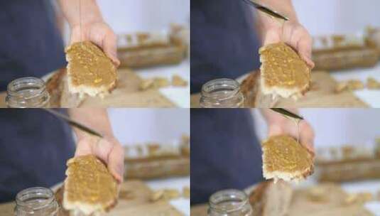 女性的手在一片涂有花生酱的面包上涂蜂蜜高清在线视频素材下载