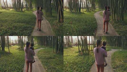 妈妈抱着小女儿散步阳光竹林公园高清在线视频素材下载