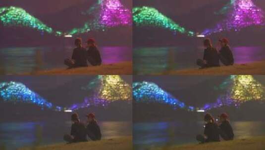两个女孩坐在江边看夜景高清在线视频素材下载