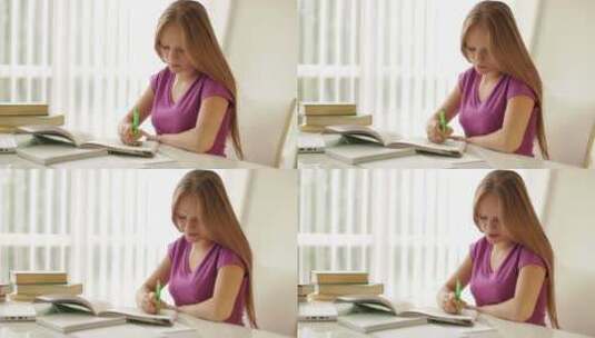 女孩坐在桌子上写练习册高清在线视频素材下载