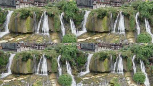 航拍悬崖上的古镇瀑布流水湖南湘西芙蓉镇高清在线视频素材下载