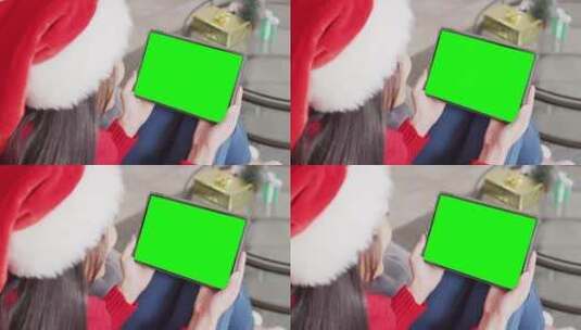 圣诞帽女孩在平板电脑上挑选礼物绿幕抠像高清在线视频素材下载
