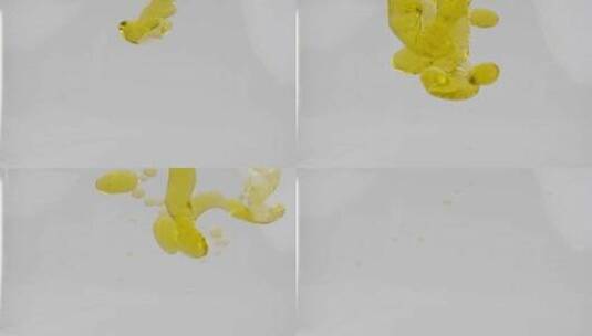 黄色植物油倒入水中形成气泡。使用慢动作180fps 1080p相机。高清在线视频素材下载