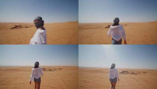 戴着围巾和太阳镜在沙漠沙丘上散步的年轻高加索女人高清在线视频素材下载