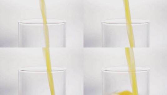 往白色背景前的玻璃杯里倒入橙汁高清在线视频素材下载