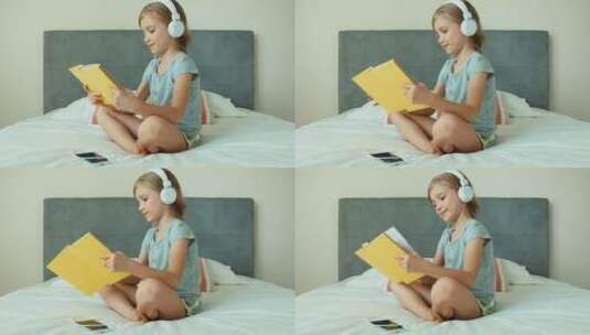 女孩在耳机里听音乐看书高清在线视频素材下载