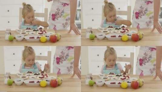小女孩把浆果放在松饼上高清在线视频素材下载
