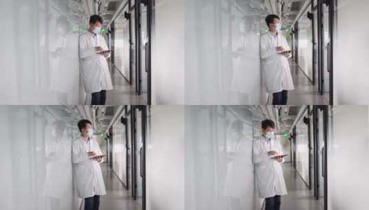 年轻医学科研人员走廊里使用平板电脑高清在线视频素材下载
