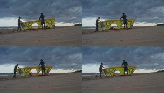 风筝冲浪运动员乌云下整理风筝高清在线视频素材下载