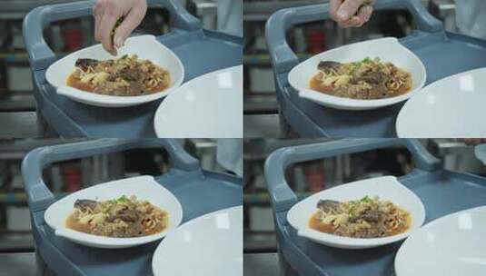厨师往装好盘子的菜中撒葱花高清在线视频素材下载