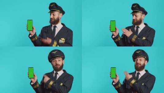 微笑的男飞行员使用带绿屏的电话高清在线视频素材下载