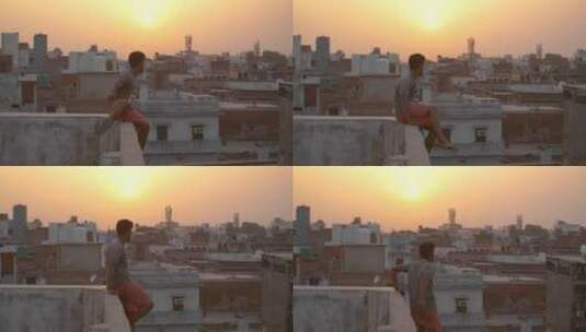 日落时分爬上屋顶的男人高清在线视频素材下载