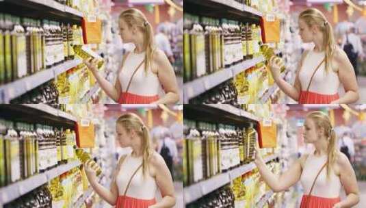 女子在超市挑选橄榄油高清在线视频素材下载